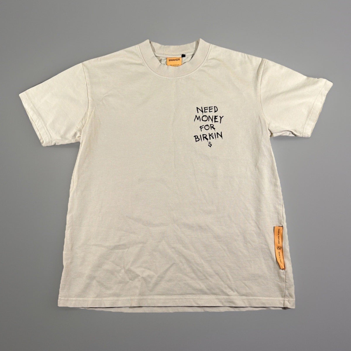 SMAKER cream-colored t-shirt features the graphics NEED MONEY FOR BIRKIN - Fashi