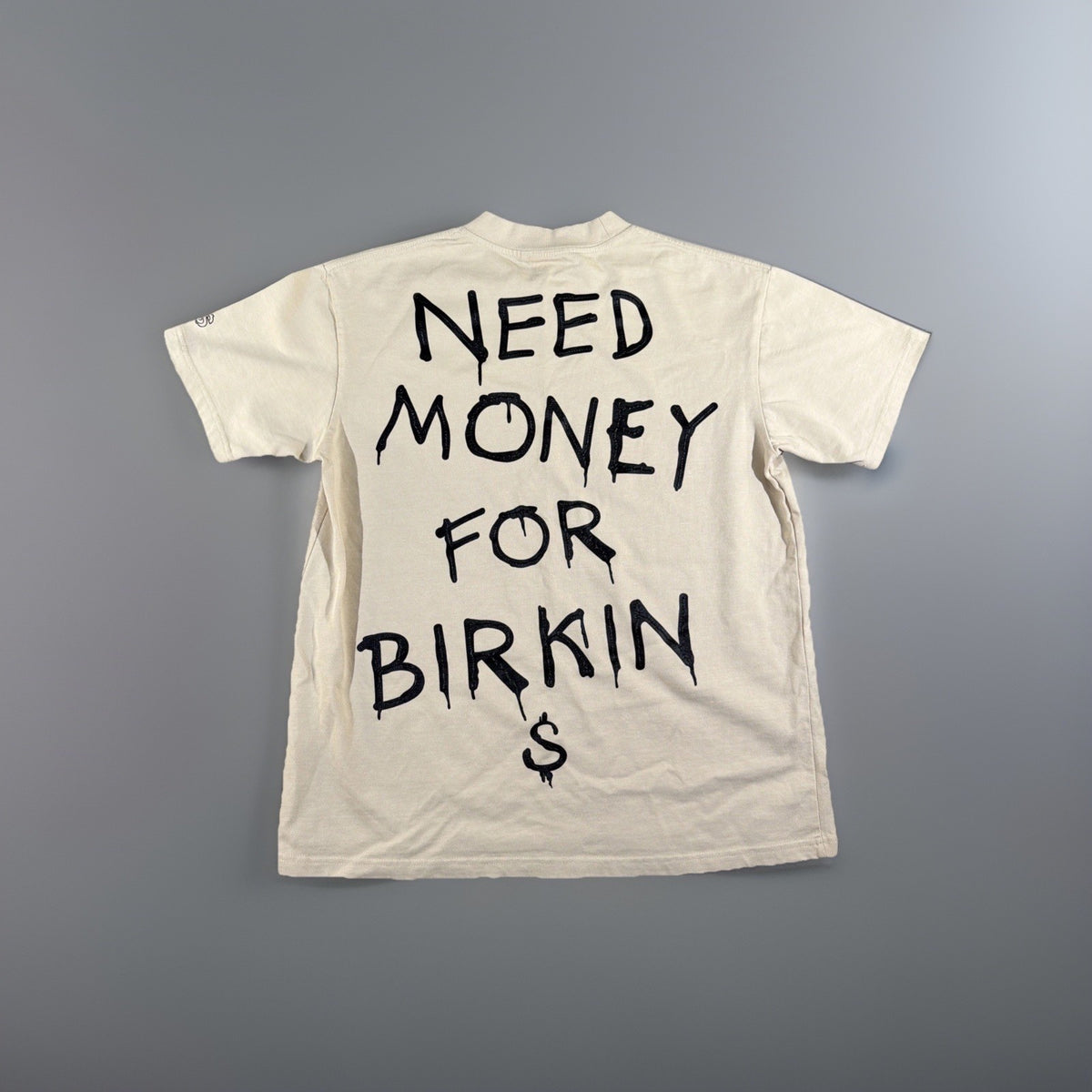 SMAKER cream-colored t-shirt features the graphics NEED MONEY FOR BIRKIN - Fashi