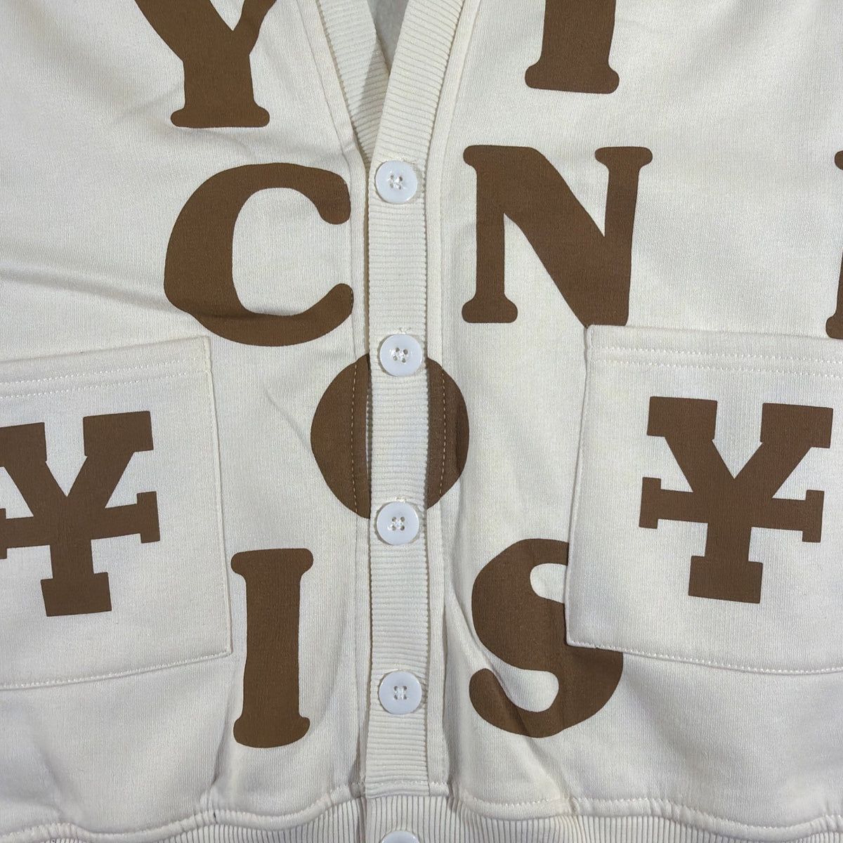 DirtyCoins brand cardigan featuring a distinctive all-over letter pattern