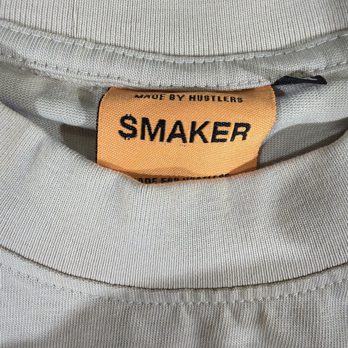 SMAKER cream-colored t-shirt features the graphics NEED MONEY FOR BIRKIN - Fashi